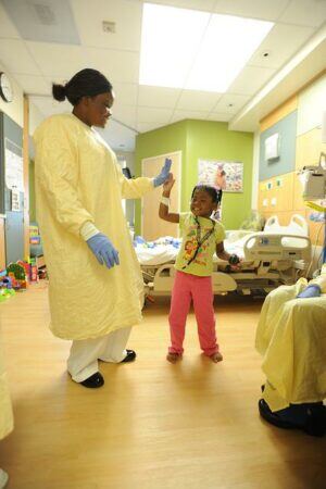 nurse and child in pediatric medical clinic with child-friendly Houston wall signs